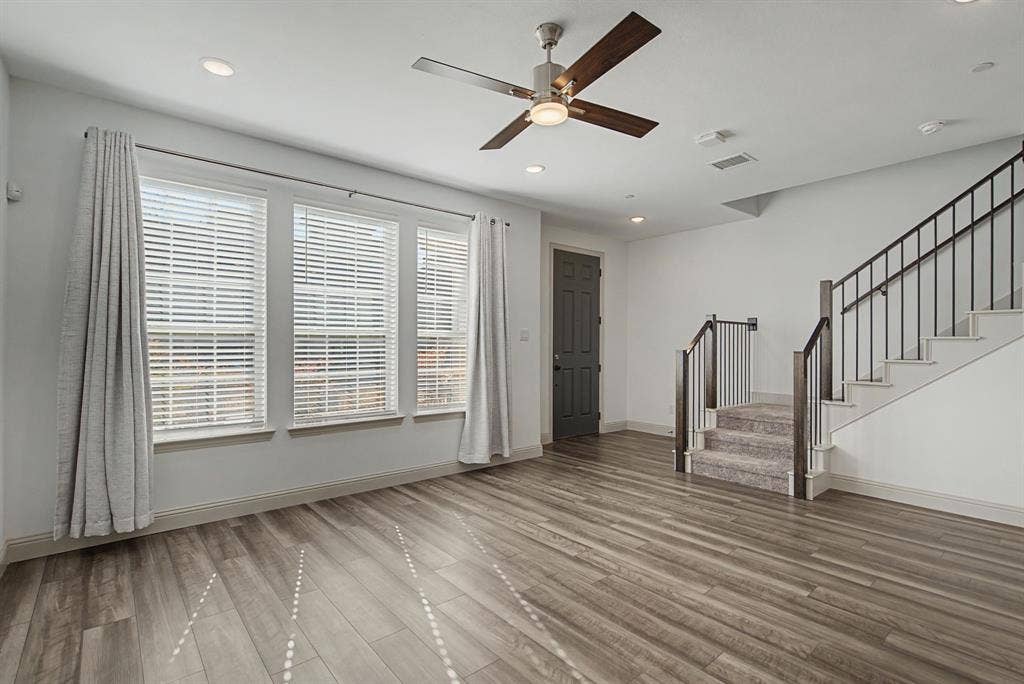 6032 Silverado Trail, McKinney, TX 75070 Spacious living area featuring wood-finish flooring, a contemporary ceiling fan, and recessed lighting