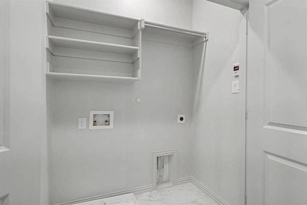 6032 Silverado Trail, McKinney, TX 75070 Utility room featuring built-in shelving, a clothes hanging rod, and marble-look tile flooring