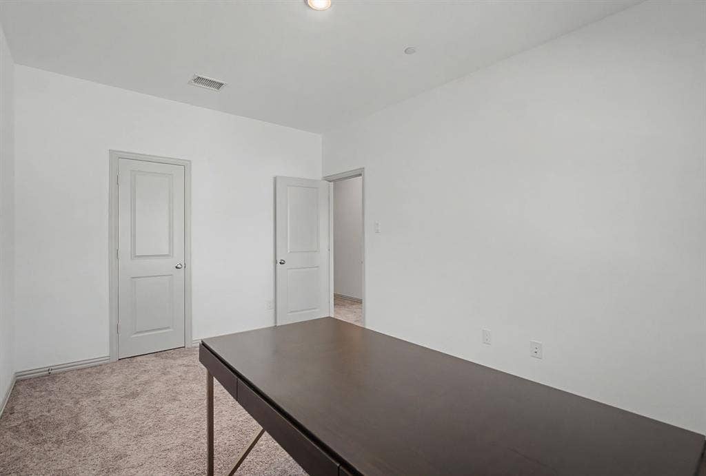 6032 Silverado Trail, McKinney, TX 75070 Interior room featuring light gray walls, two paneled interior doors, and textured carpet flooring