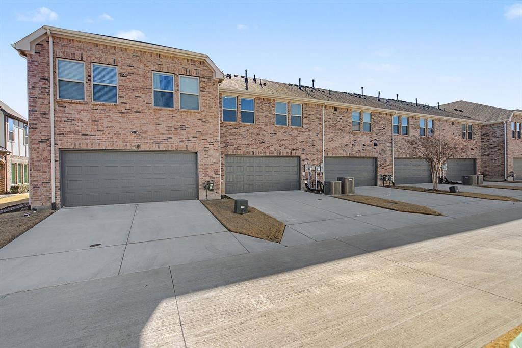 6032 Silverado Trail, McKinney, TX 75070 Townhome-style residences featuring brick exteriors, multiple window configurations, and individual garages