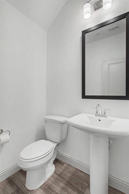 6032 Silverado Trail, McKinney, TX 75070 Pedestal sink with chrome faucet, framed mirror, and wood-finish flooring