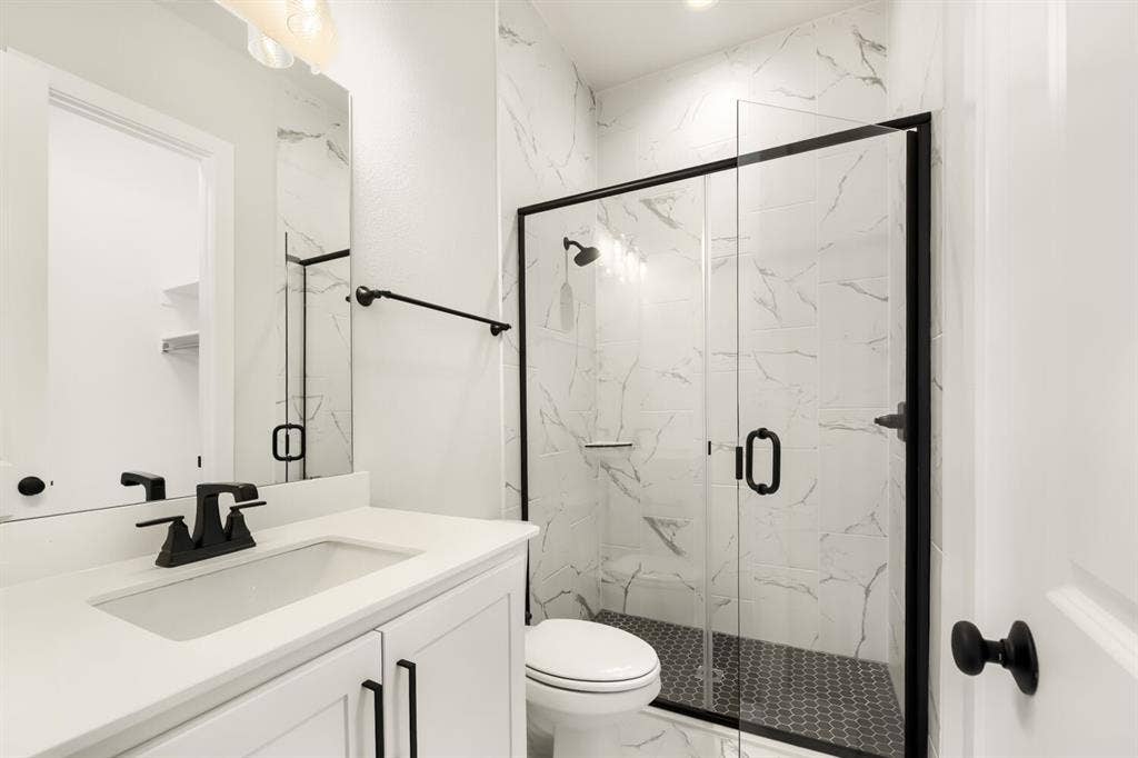 Modern bathroom featuring a white vanity with a rectangular undermount sink, matte black faucet, and matching black hardware