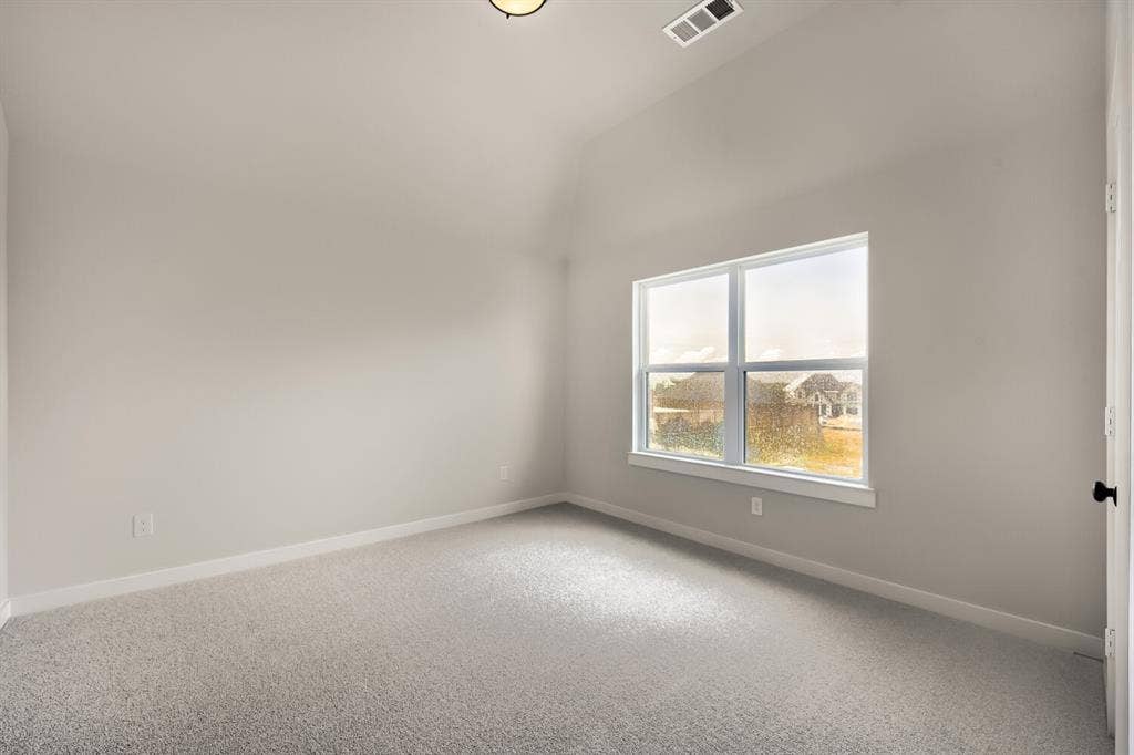 Room featuring vaulted ceilings, light gray carpeting, and a large window with white trim