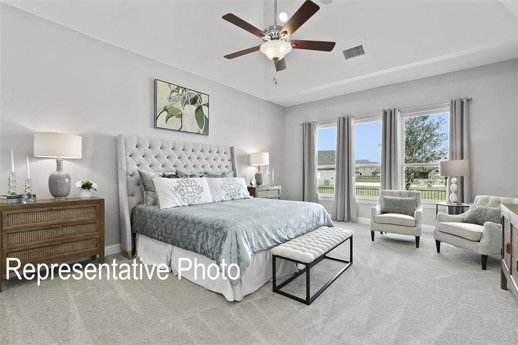 4384 Laurel Trail, Midlothian, TX 76065 Bedroom featuring light gray carpeting, a tray ceiling, and a ceiling fan with integrated lighting