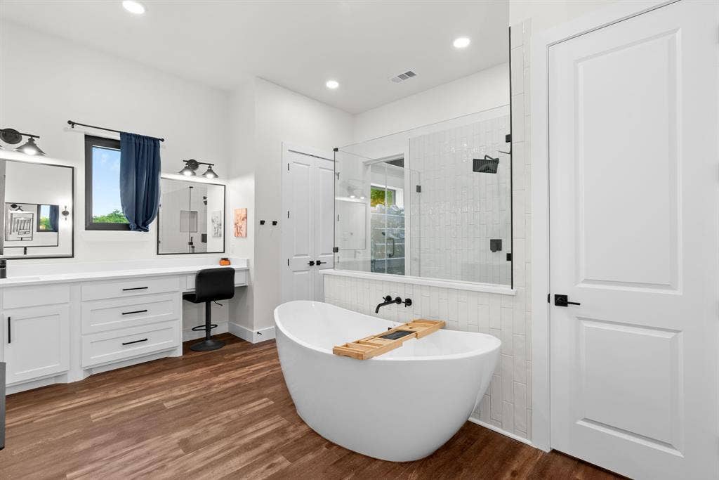 3621 Fritz Lane, Corinth, TX 76208 Bathroom featuring a freestanding soaking tub, a walk-in shower with glass enclosure, and a double vanity with ample counter space