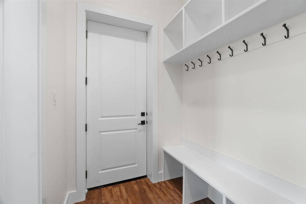 3621 Fritz Lane, Corinth, TX 76208 Mudroom featuring built-in white shelving, integrated bench seating, and multiple coat hooks