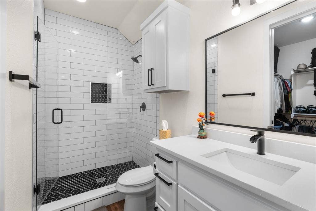 3621 Fritz Lane, Corinth, TX 76208 Modern bathroom featuring a frameless glass shower enclosure with subway tile walls and a hexagonal tile floor