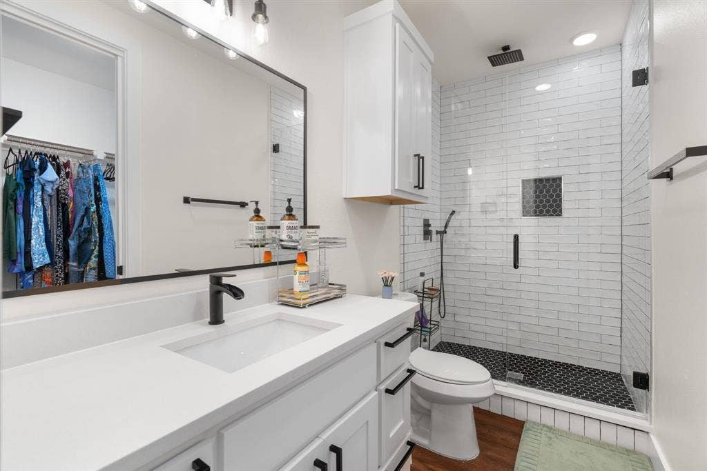 3621 Fritz Lane, Corinth, TX 76208 Contemporary bathroom featuring a spacious walk-in shower with white subway tile, dark hexagonal floor tiles, and a rainfall shower head