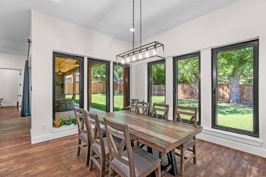 3621 Fritz Lane, Corinth, TX 76208 Open-concept living space featuring wood-finish flooring and a contemporary linear chandelier