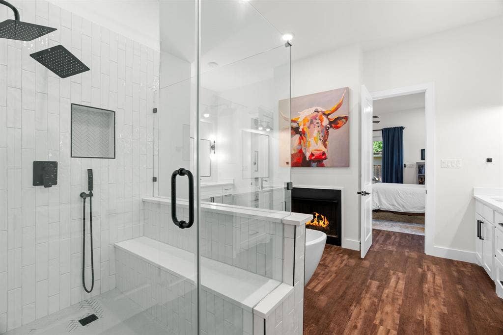 3621 Fritz Lane, Corinth, TX 76208 Spacious bathroom featuring a glass-enclosed shower with dual shower heads, a built-in shower bench, and a tiled accent niche