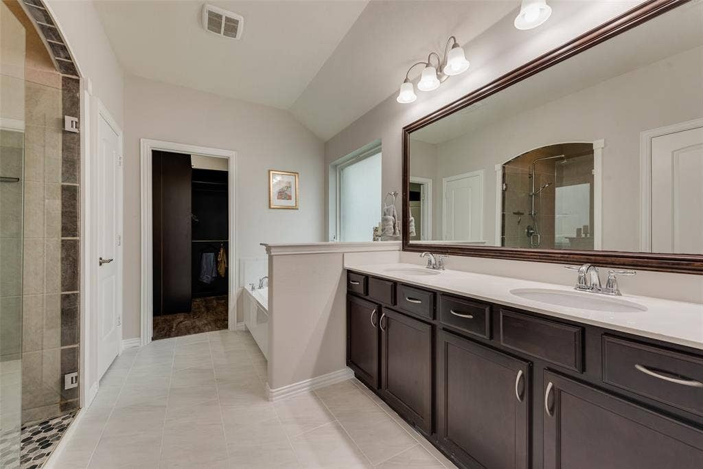 1432 Westview Lane, Northlake, TX 76226 Primary bathroom with dual sinks, remodeled shower, ceramic tile floors and huge walk-in closet with modular system at 1432 Westview Ln in the Canyon Falls community in Northlake, TX