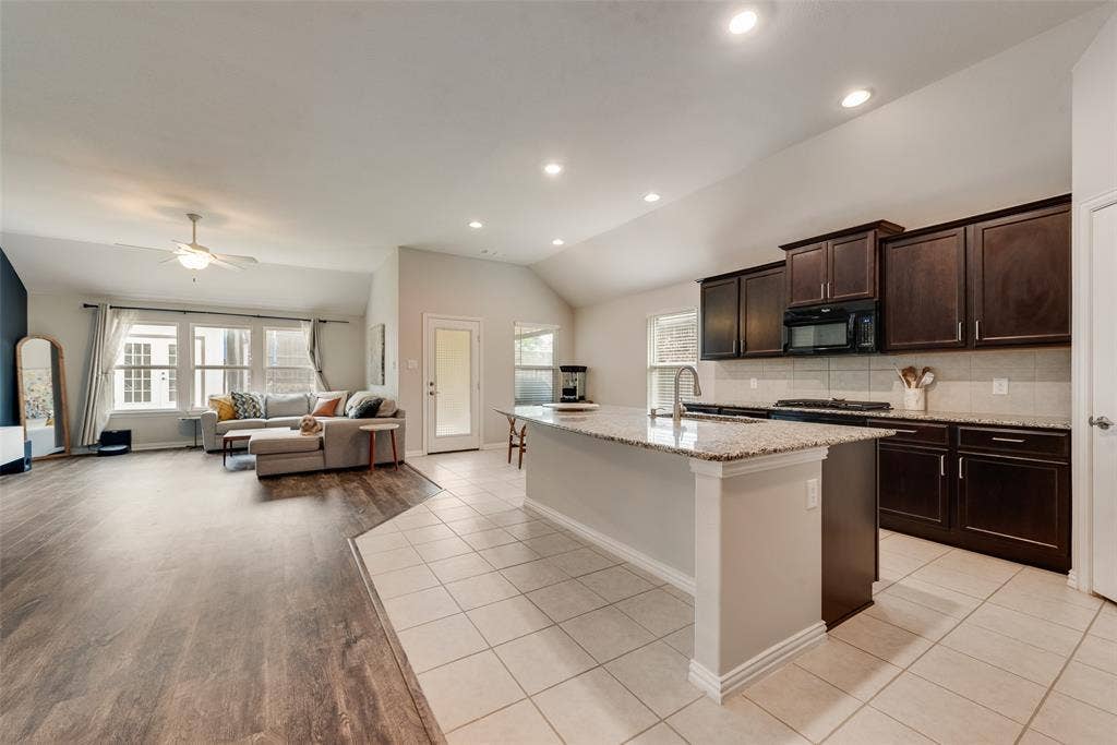 1432 Westview Lane, Northlake, TX 76226 Spacious kitchen with oversized island and granite countertops open to the living and dining areas at 1432 Westview Ln in the Canyon Falls community in Northlake, TX
