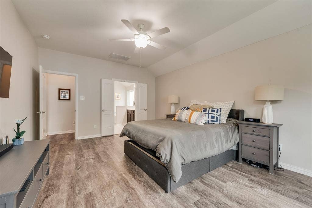 1432 Westview Lane, Northlake, TX 76226 Primary bedroom with new LVP flooring, ensuite bathroom and abundant natural light at 1432 Westview Ln in the Canyon Falls community in Northlake, TX