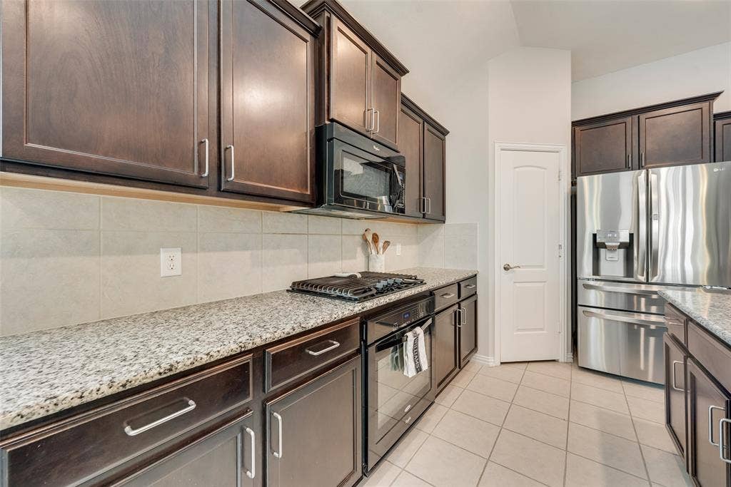 1432 Westview Lane, Northlake, TX 76226 Spacious kitchen with oversized island, granite countertops, gas cooktop and walk-in pantry at 1432 Westview Ln in the Canyon Falls community in Northlake, TX