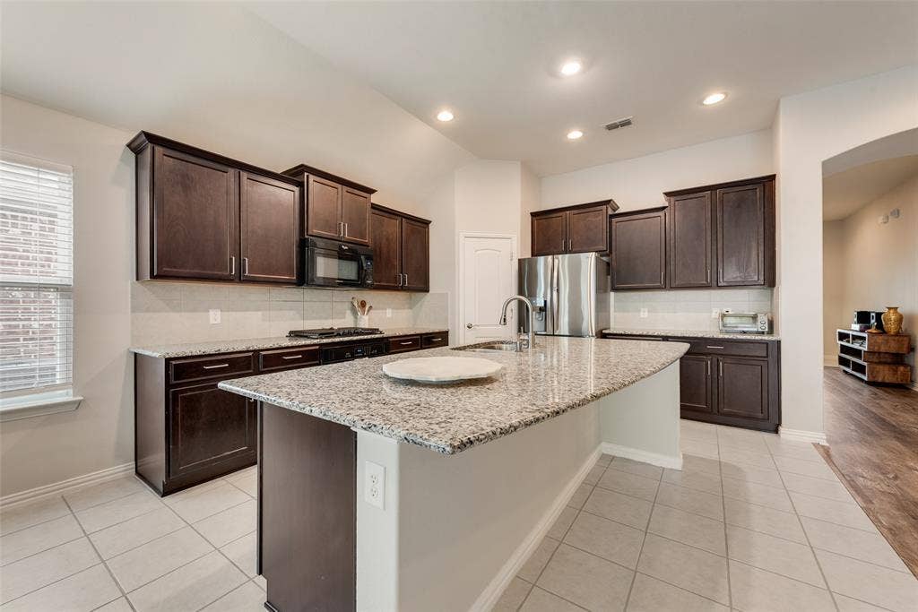 1432 Westview Lane, Northlake, TX 76226 Spacious kitchen with oversized island, granite countertops, gas cooktop and walk-in pantry at 1432 Westview Ln in the Canyon Falls community in Northlake, TX