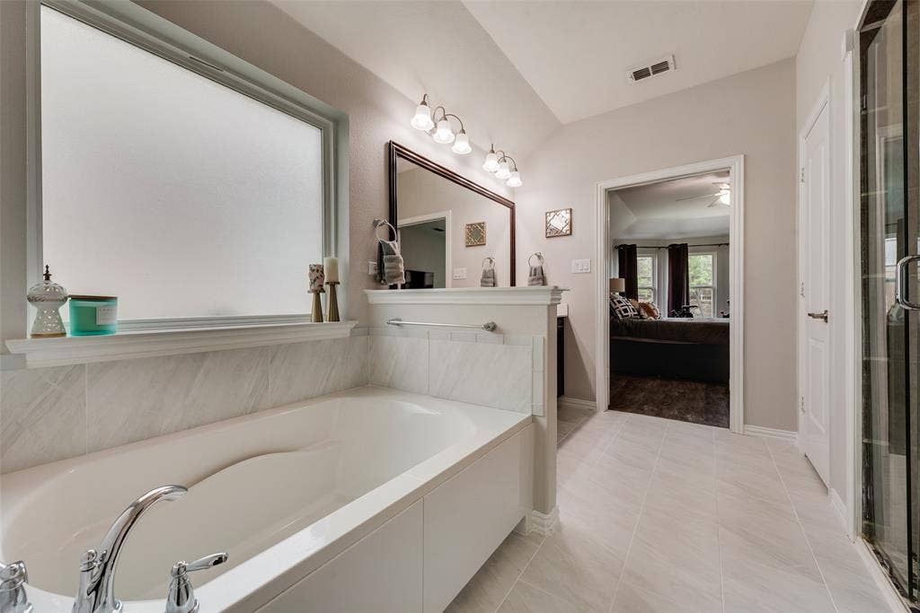 1432 Westview Lane, Northlake, TX 76226 Primary bathroom with dual sinks, remodeled shower, ceramic tile floors and huge walk-in closet with modular system at 1432 Westview Ln in the Canyon Falls community in Northlake, TX