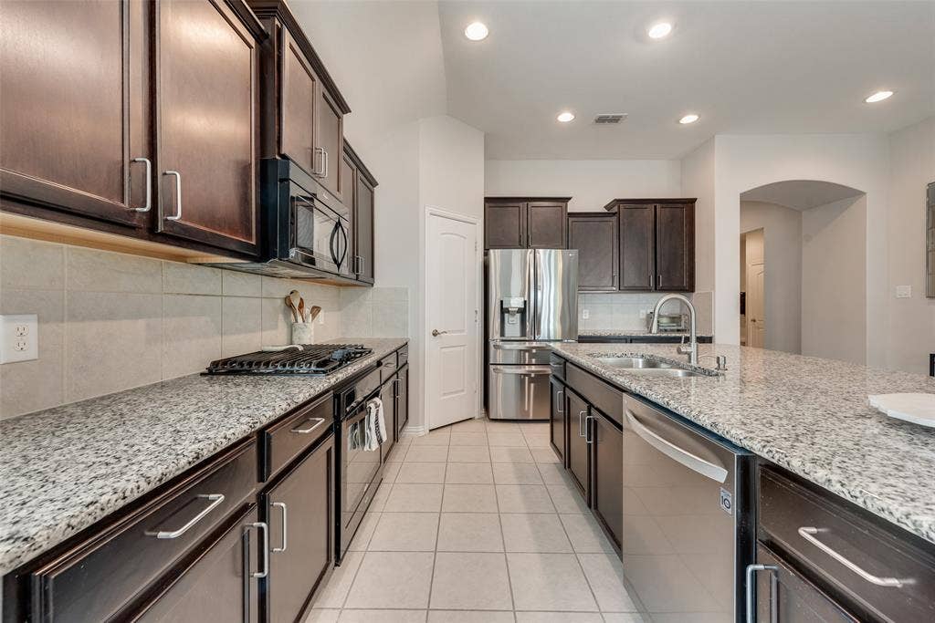 1432 Westview Lane, Northlake, TX 76226 Spacious kitchen with oversized island, granite countertops, gas cooktop and walk-in pantry at 1432 Westview Ln in the Canyon Falls community in Northlake, TX