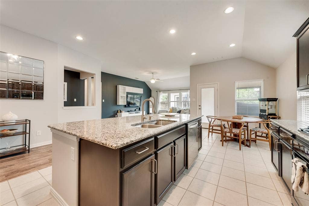 1432 Westview Lane, Northlake, TX 76226 Spacious kitchen with oversized island, granite countertops, gas cooktop and walk-in pantry looking into dining area at 1432 Westview Ln in the Canyon Falls community in Northlake, TX