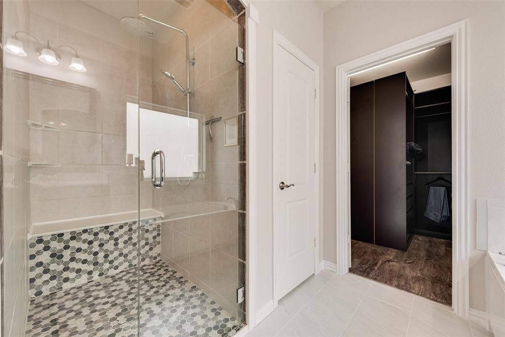 1432 Westview Lane, Northlake, TX 76226 Primary bathroom with dual sinks, remodeled shower, ceramic tile floors and huge walk-in closet with modular system at 1432 Westview Ln in the Canyon Falls community in Northlake, TX