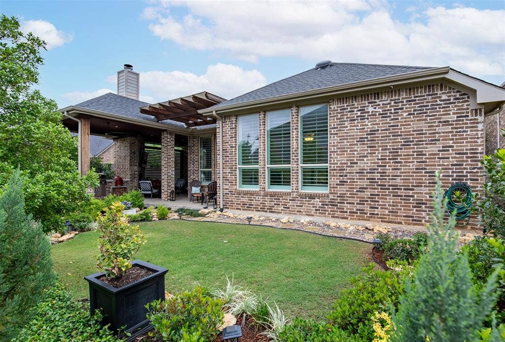 1408 9th Street, Argyle, TX 76226 Gorgeous landscaping can be enjoyed from every angle of this backyard, creating a beautifully cohesive and serene outdoor setting.