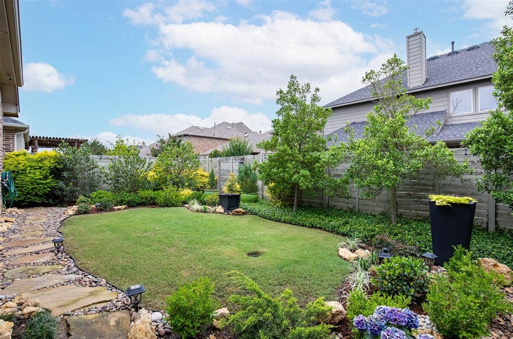 1408 9th Street, Argyle, TX 76226 This backyard is truly a place to unwind and relax, surrounded by beautifully maintained landscaping that creates a peaceful outdoor retreat.