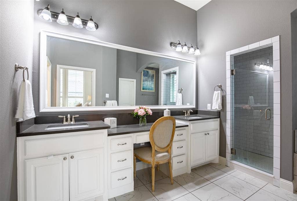 1408 9th Street, Argyle, TX 76226 The spa-like ensuite primary bathroom features double sinks and a separate shower, offering a relaxing and functional retreat.