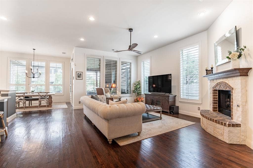 1408 9th Street, Argyle, TX 76226 The oversized living room is bathed in natural light and beautifully anchored by a stone gas fireplace, offering a warm and inviting space perfect for relaxing or entertaining.