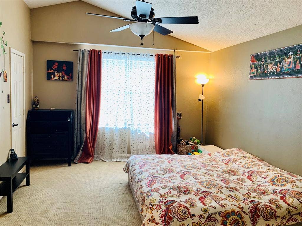 1848 Sonnet Drive, Grapevine, TX 76051 Spacious room featuring vaulted ceilings, a ceiling fan, broad window with natural light, and plush carpeting