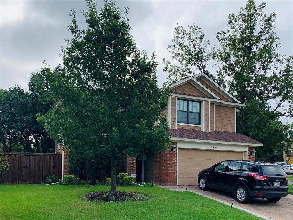 1848 Sonnet Drive, Grapevine, TX 76051 Two-story residence featuring a brick facade with shake siding accents, a prominent front-facing gable, and an attached two-car garage