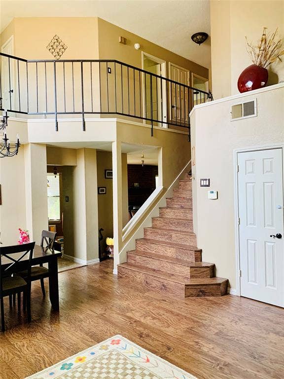 1848 Sonnet Drive, Grapevine, TX 76051 Open-concept interior featuring wood-finish flooring, a prominent staircase with matching wood-finish treads, and a second-story landing framed by a black metal railing