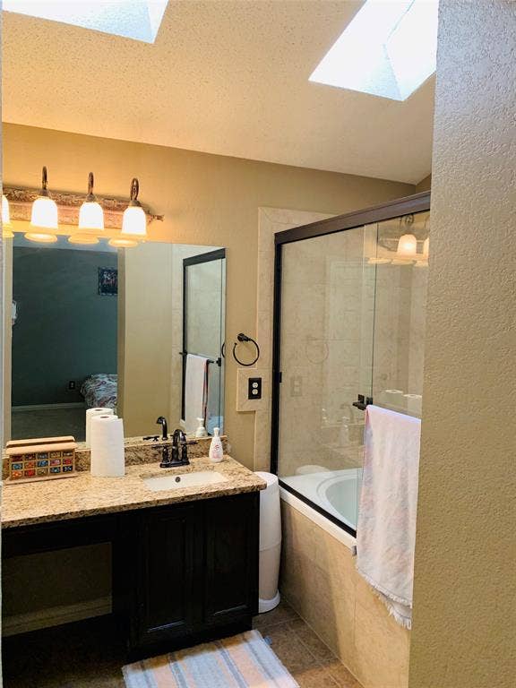 1848 Sonnet Drive, Grapevine, TX 76051 Bathroom featuring a vanity with a granite-finish countertop, undermount sink, and dark wood cabinetry