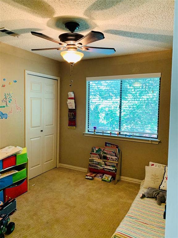 1848 Sonnet Drive, Grapevine, TX 76051 Carpeted room featuring a ceiling fan with integrated lighting, a window with horizontal blinds, and a bi-fold closet door