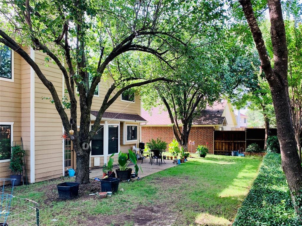 1848 Sonnet Drive, Grapevine, TX 76051 Spacious backyard featuring a manicured lawn, established trees, and a concrete patio area