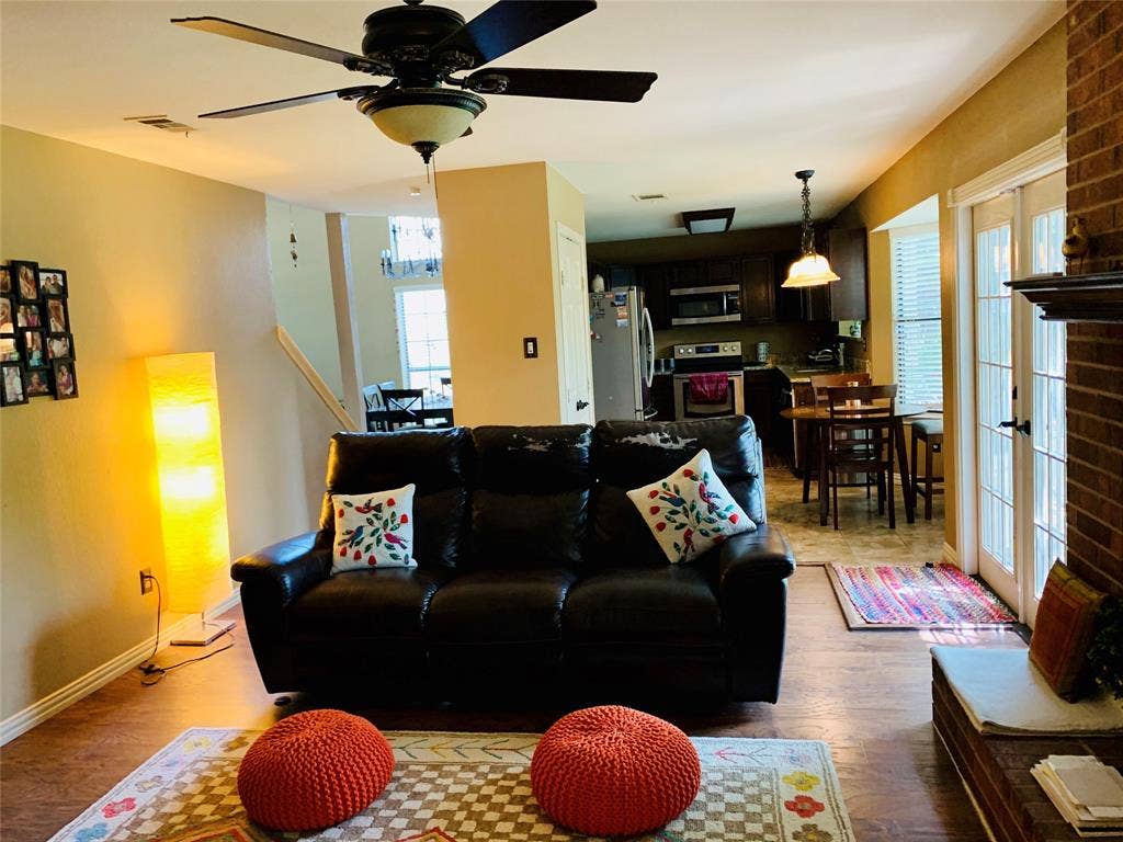 1848 Sonnet Drive, Grapevine, TX 76051 Living area featuring wood-finish flooring, a ceiling fan with integrated lighting, and a brick fireplace surround with a mantel