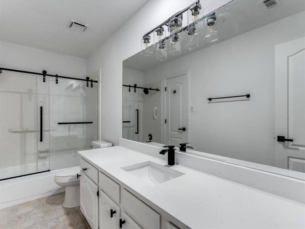 736 Sunkist Lane, Plano, TX 75025 White vanity with an integrated sink, black matte faucet, and matching black hardware