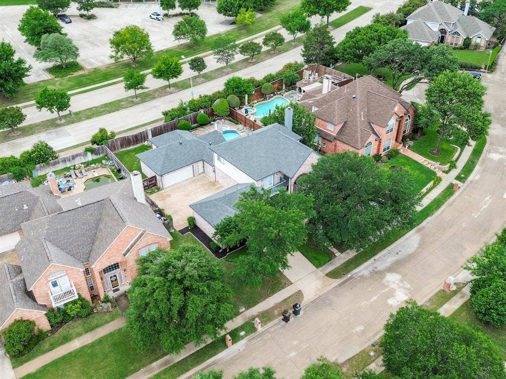 736 Sunkist Lane, Plano, TX 75025 Aerial perspective showcasing a residential property with a private swimming pool, extensive patio space, and mature landscaping