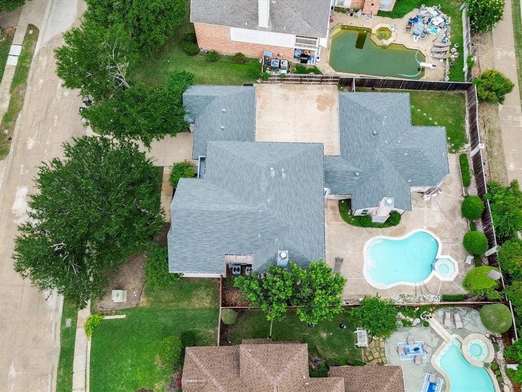 736 Sunkist Lane, Plano, TX 75025 Expansive property featuring a multi-level roofline, a large backyard swimming pool with an integrated spa, concrete patio space, and mature trees providing natural landscaping