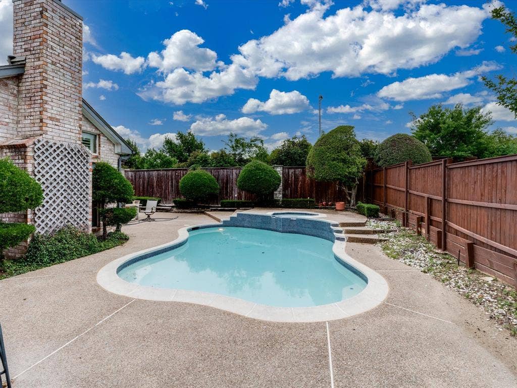 736 Sunkist Lane, Plano, TX 75025 Outdoor oasis featuring a freeform swimming pool with integrated spa and aggregate concrete decking