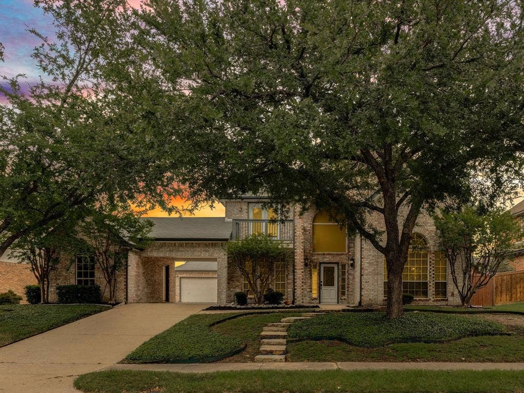 736 Sunkist Lane, Plano, TX 75025 Brick facade residence featuring a two-car garage, concrete driveway, and mature landscaping