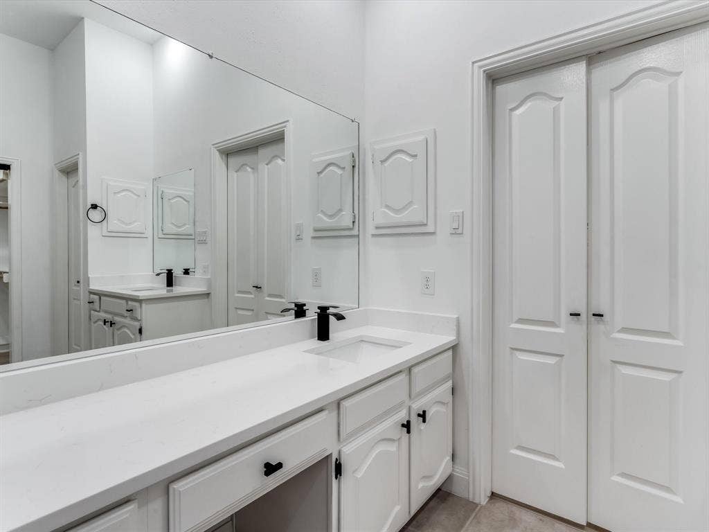 736 Sunkist Lane, Plano, TX 75025 Vanity area featuring a continuous countertop with integrated sinks and matte black fixtures