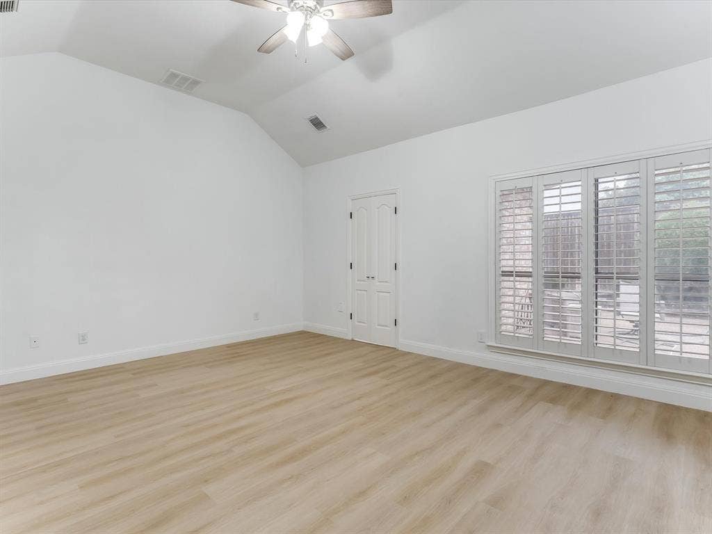 736 Sunkist Lane, Plano, TX 75025 Spacious room with wood-finish flooring, vaulted ceiling, and an integrated ceiling fan