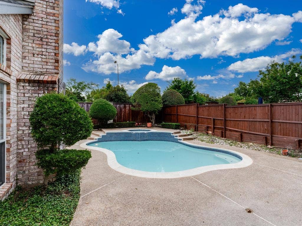 736 Sunkist Lane, Plano, TX 75025 Kidney-shaped swimming pool featuring an integrated spa with tiled steps
