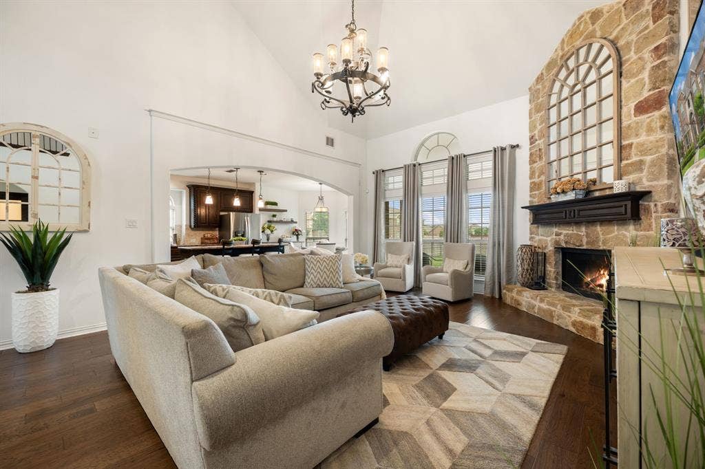 Spacious living area featuring a vaulted ceiling and wood-finish flooring