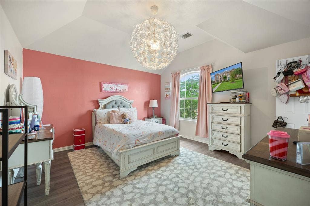 Vaulted ceiling bedroom with a large arched window, wood-finish flooring, and a contemporary spherical light fixture