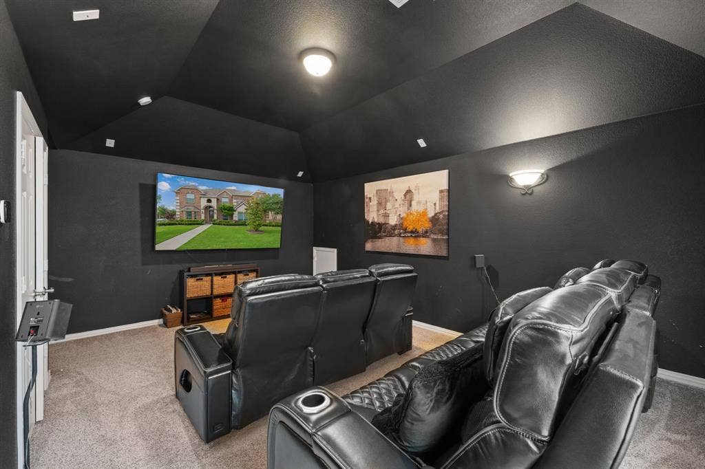 Dedicated media room featuring dark walls and ceiling, recessed lighting, wall sconce, and carpeted flooring