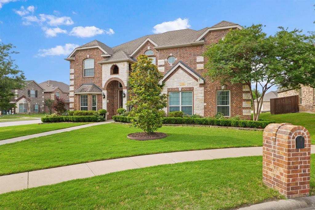 Brick and stone facade residence featuring an arched entryway