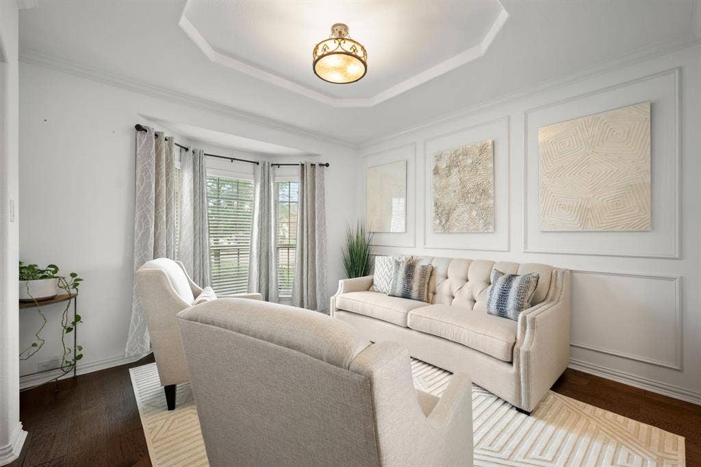 Formal living space featuring dark wood-finish flooring and a bay window