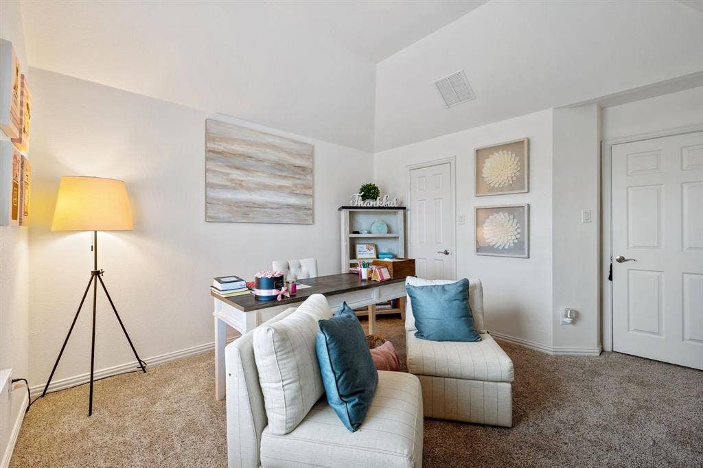 Carpeted interior space featuring a vaulted ceiling, white paneled doors, and light wall finishes