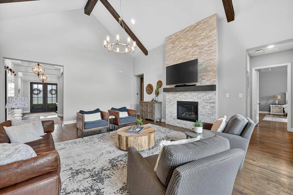 7108 Eagles Ridge Court, Argyle, TX 76226 This spacious single-story is filled with elevated details—soaring wood-beamed ceilings, hand-scraped hardwood floors, plantation shutters, designer lighting, and a dramatic floor-to-ceiling stacked stone fireplace.