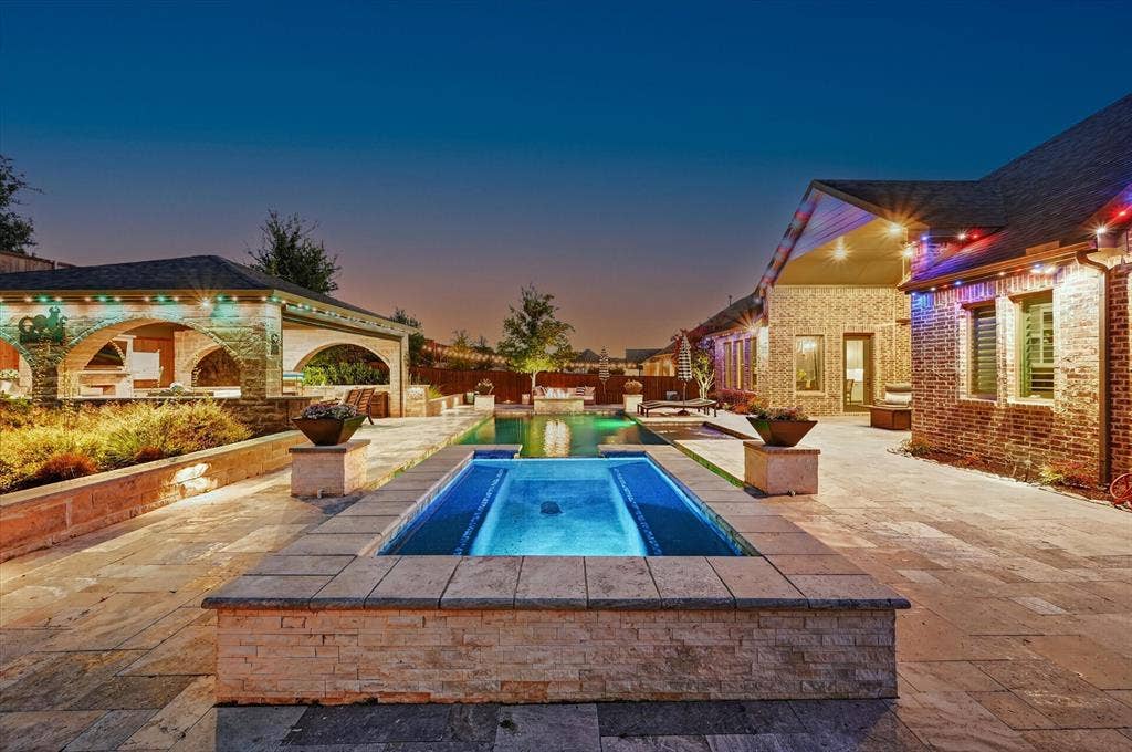 7108 Eagles Ridge Court, Argyle, TX 76226 Enjoy a heated PebbleTec pool and spa, fire pit, silver travertine decking, putting green, lush landscaping with full irrigation, and low-maintenance turf.